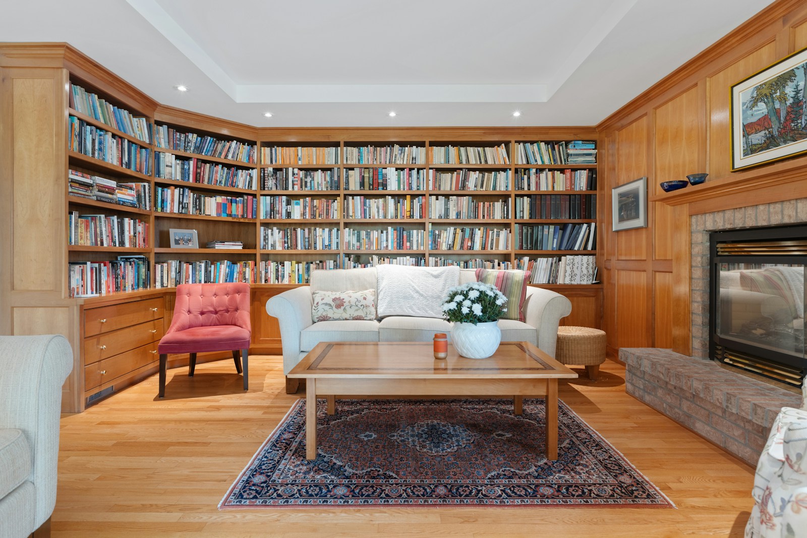 A quiet reading room with wooden tables, lamps, and shelves of books