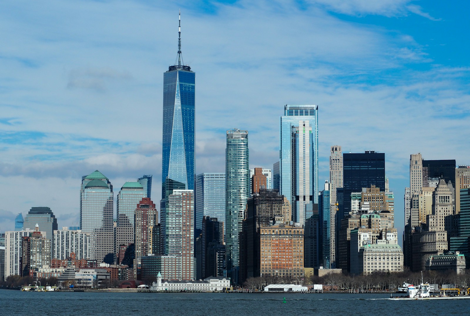 A wide street-level view of skyscrapers in a financial district, shot upward from the sidewalk between the buildings